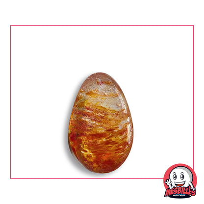 Bille Oeuf Cristal Moucheté Orange et Rouge en verre incolore moucheté d'orange cuivré, de rouge et de jaune, vue de côté, environ 25 mm de haut