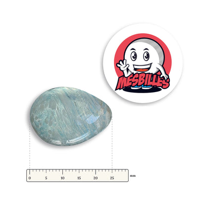 Bille Oeuf Cristal Moucheté Bleu-Clair et Blanc couchée à côté d'une règle graduée, environ 25 mm de long